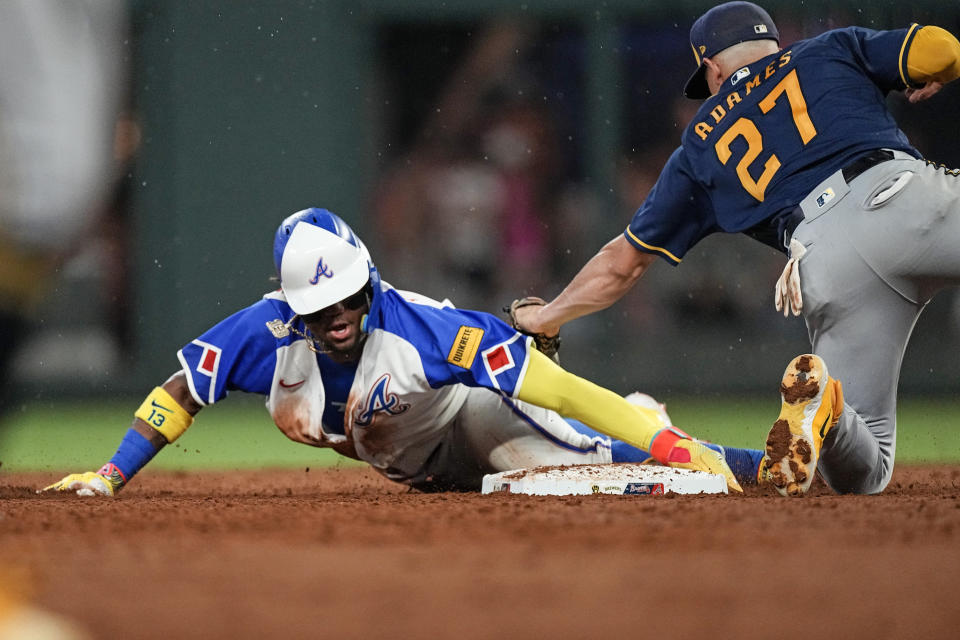 Atlanta Braves' Ronald Acuna Jr. (13) beats a tag by Milwaukee Brewers shortstop Willy Adames (27) to steal second base in the fifth inning of a baseball game Friday, July 28, 2023, in Atlanta. (AP Photo/John Bazemore)