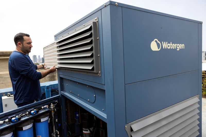 A worker handles a machine, that according to Watergen can extract up to 1000 litres of drinking water per day from the air, at their office, in Petah Tikva