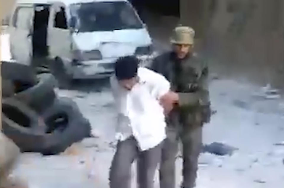 FILE - This frame grab from a 2013 video shows a blindfolded Syrian man pushed by a Syrian agent before he was shot dead and thrown into a large pit full of bodies in the Tadamon neighborhood of Damascus, Syria. The U.S. State Department on Monday banned entry into the U.S. of a Syrian intelligence member who appeared in a video leaked last year showing him fatally shooting people during the country's 12-year conflict. (AP Photo, File)