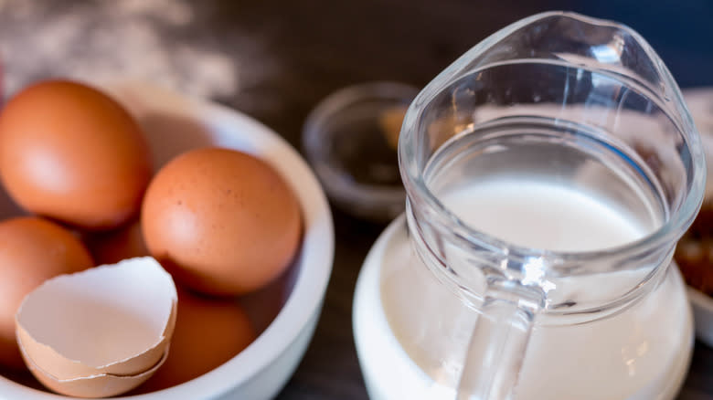 Jug of milk next to bowl of eggs