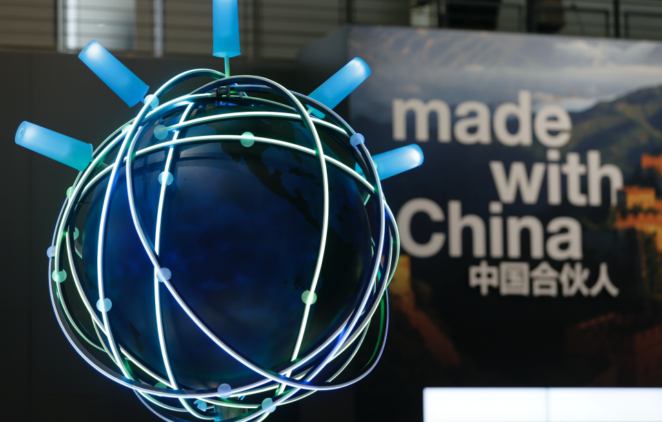 The motto of this year's CeBit trade fair ' Made With China' is seen next to a rotating globe at the IBM booth during the fair in Hanover March 16, 2015. The world's biggest computer and software fair will open to the public from March 16 to 20. (Photo: REUTERS/Morris Mac Matzen)