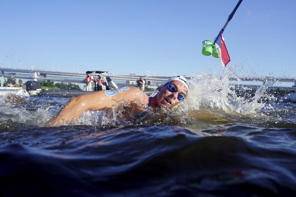 Gregorio Paltrinieri, of Italy, swims through a feeding station during the men's marathon swimming event at the 2020 Summer Olympics, Thursday, Aug. 5, 2021, in Tokyo. (AP Photo/David Goldman)