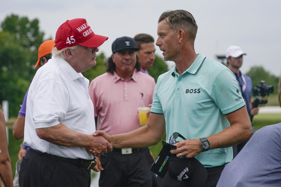 Henrik Stenson, right, of Sweden, greets former President Donald Trump after winning the individual competition of the LIV Golf Invitational at Trump National in Bedminster, N.J., Sunday, July 31, 2022. (AP Photo/Seth Wenig)