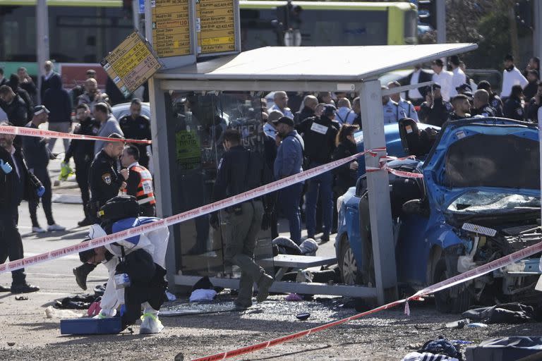 Un equipo forense de la policía israelí trabaja en el lugar de un ataque con un auto en una parada de colectivo en Ramot, un asentamiento judío en el este de Jerusalén, el viernes 10 de febrero de 2023.