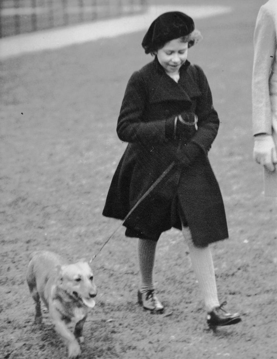 FILE - Princess Elizabeth takes her pet dog for a walk in Hyde Park, London, on Feb. 26. 1936. It's widely known that Elizabeth loved corgi dogs, Princess Diana reportedly called the animals the queen's "moving carpet" because they accompanied her everywhere. (AP Photo, File)