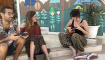 Canadian tourist Lambert Desrosiers Gaudette, left and British tourist Emma Snashford, listen as another stranded foreign tourist plays ukulele at a hostel in New Delhi, India, Thursday, April 2, 2020. Dozens of tourists from Britain, Canada and Australia are finding themselves stranded in the Indian capital with their vacations abruptly ended by India’s three-week lockdown and stopping of international flights amid new coronavirus. (AP Photo/Shonal Ganguly)