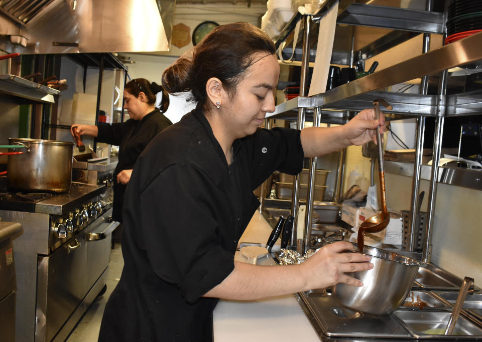 Casandra Lugo, right, and Josefina Ornelas work in the Mexican restaurant Los Saguaros, Aug. 26, 2021, in Watford City, N.D., part of McKenzie County. A drilling boom made McKenzie the fastest growing county in the U.S over the past decade, according to the 2020 census. (AP Photo/Matthew Brown)