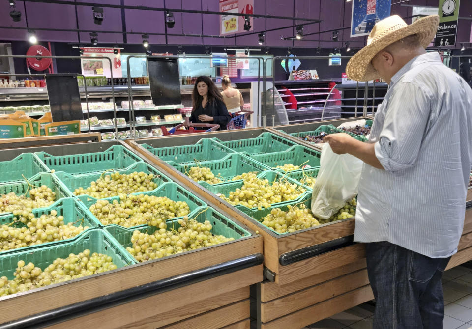 People shop at a supermarket, in Tunis, Tunisia, Monday, Oct. 10, 2022. Sugar, vegetable oil, rice, even bottled water – Tunisians have suffered shortages of multiple staples in recent weeks. And costs are soaring on products still available. (AP Photo/Hassene Dridi)