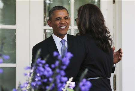 U.S. President Barack Obama greets an audience member, one of many Americans the White House says will benefit from the opening of health insurance marketplaces under the Affordable Care Act, after speaking in the Rose Garden of the White House in Washington, October 1, 2013. REUTERS/Larry Downing