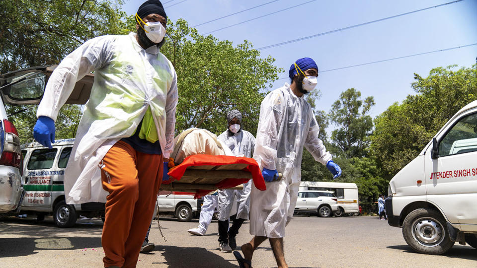 Voluntary health workers, pictured here carrying the body of a deceased Covid-19 patient.