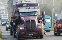 Migrantes se trepan a un camión que parte San Pedro Sula, Honduras, miércoles 15 de enero de 2020, con la esperanza de formar una caravana hacia el lejano Estados Unidos. (AP Foto/Delmer Martinez)