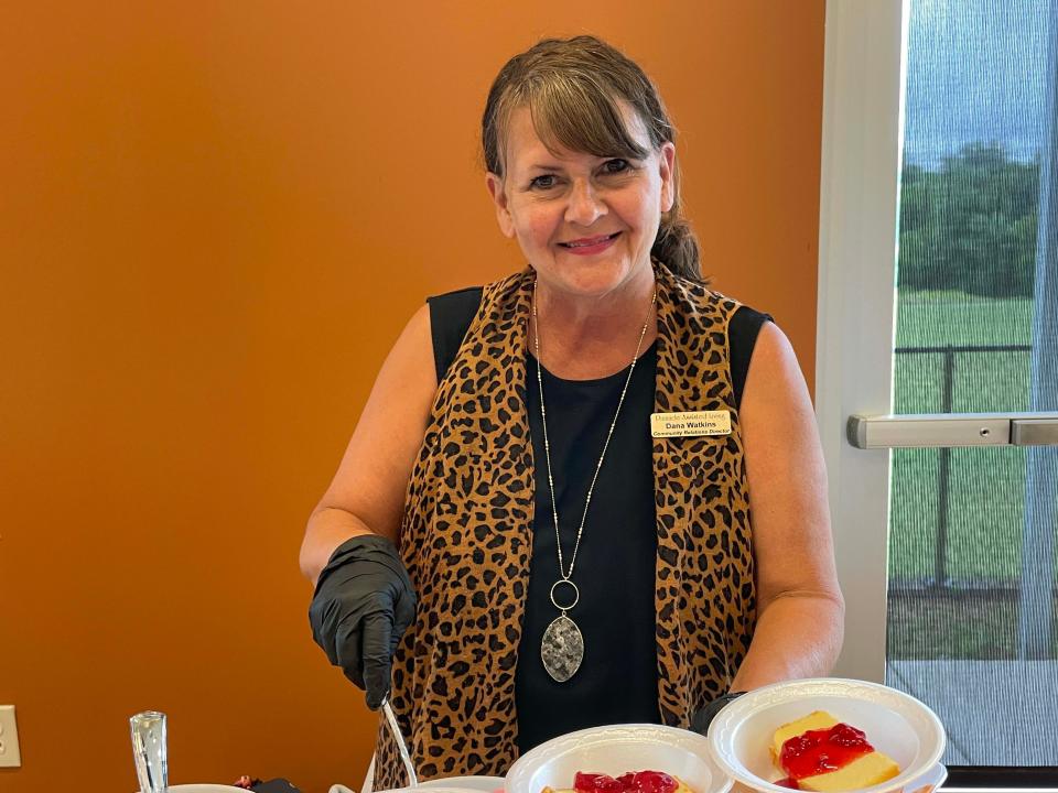 Dana Watkins serves up cheesecake courtesy of Pinnacle Assisted Living at the luau at Karns Senior Center Tuesday, June 7, 2022.