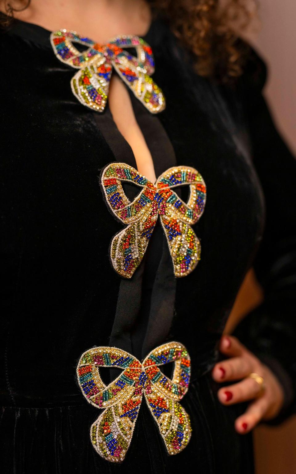 The dress features crystal-embellished bows on the bodice.