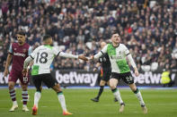 Liverpool's Andrew Robertson, right, celebrates with teammate Cody Gakpo after scoring his side's first goal during the English Premier League soccer match between West Ham United and Liverpool at London stadium in London, Saturday, April 27, 2024. (AP Photo/Kin Cheung)