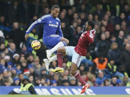 Chelsea's Didier Drogba (L) challenges West Ham United's Alex Song during their English Premier League soccer match at Stamford Bridge in London, December 26, 2014. REUTERS/Stefan Wermuth