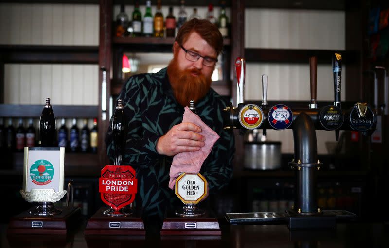 Landlord Are Kolltveit cleans the bar in the Chandos Arms pub ahead of pubs reopening following the coronavirus disease (COVID-19) outbreak, in London
