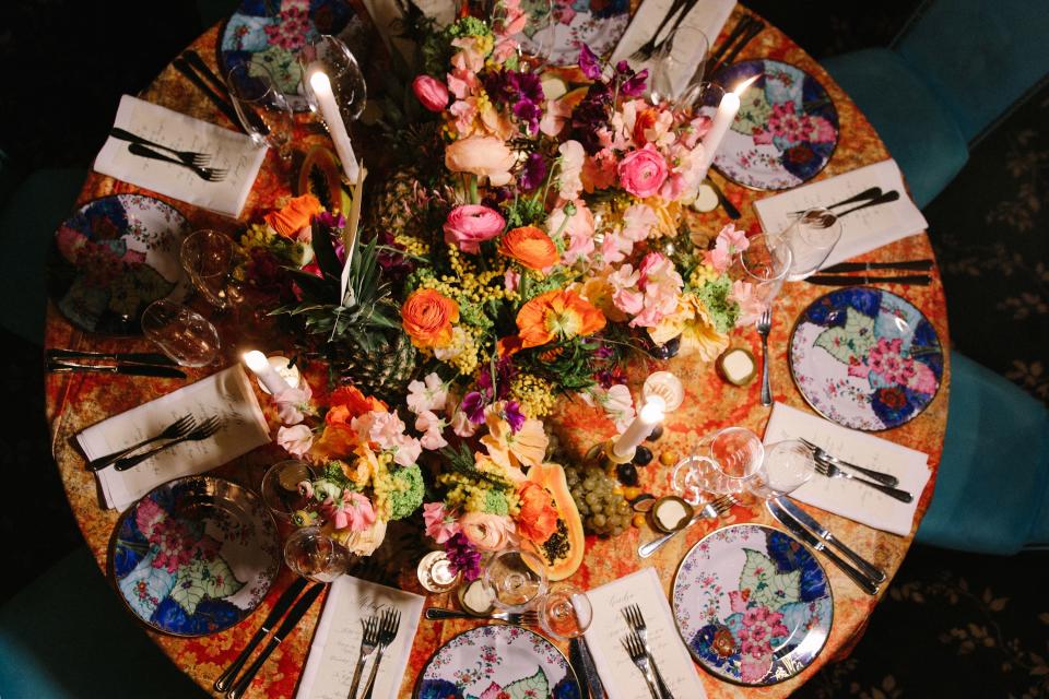 Mottahedeh tobacco-leaf chargers, Moroccan tea glasses, and antique porcelain figurines (spot the blue duck!)—all on psychedelic velvet tablecloths in alternating trippy turquoise and Yellow Submarine–y yellows and oranges—really reinforced the “Age of Innocence on Acid” vibe. As did the red silk tassels strewn between flowers and fruits.