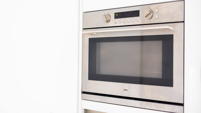stainless steel oven turned on with white background