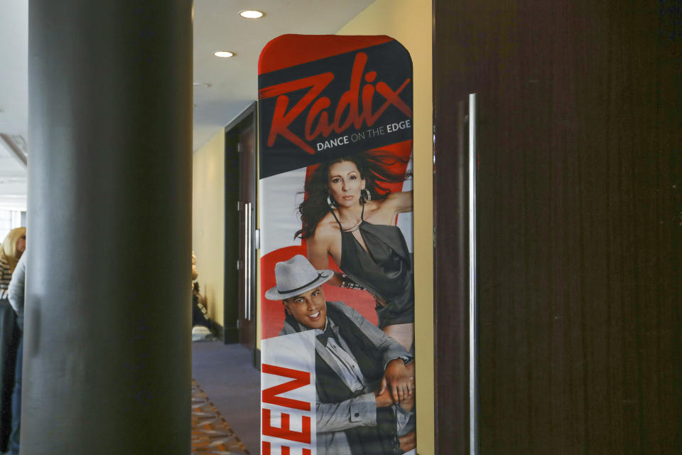 A sign points attendees to a RADIX competition room in Rosemont, Ill., on Feb. 4, 2022. Break The Floor hosts conventions in cities across North America, putting on events in hotel ballrooms every weekend over the course of a six-month season. Hundreds of studios and schools from smaller communities bring teams of dancers to the events, branded as JUMP, NUVO, 24seven, RADIX and DancerPalooza. (AP Photo/Teresa Crawford)