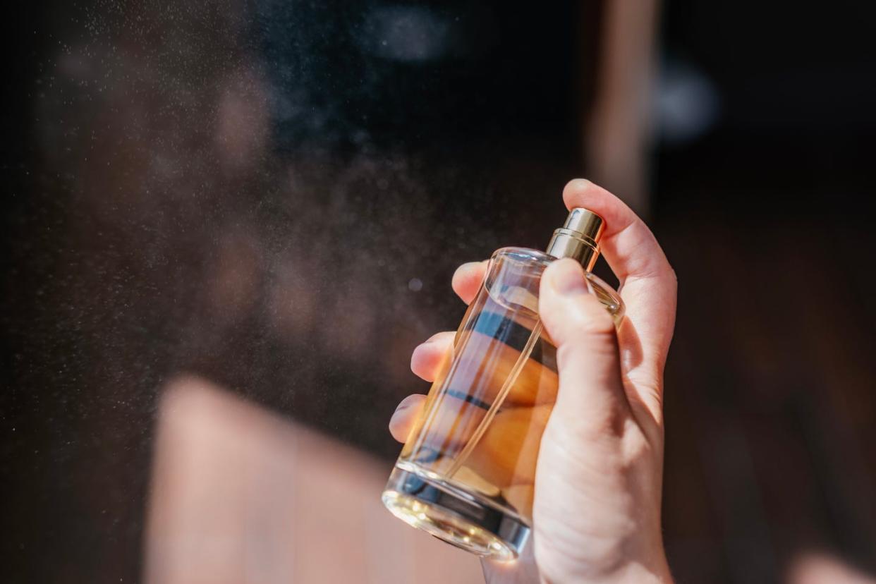 unrecognizable bottle of perfume in hand