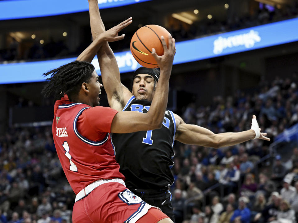 Fresno State guard Isaac Taveres, left, goes against BYU guard Trey Stewart, right, during an NCAA college basketball game in Salt Lake City, Friday, Dec. 1, 2023. (Scott G Winterton/The Deseret News via AP)