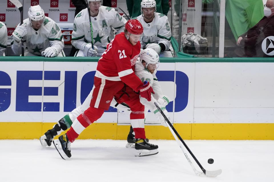 Detroit Red Wings defenseman Dennis Cholowski (21) and Dallas Stars center Joe Pavelski (16) compete for control of the puck in the first period of an NHL hockey game in Dallas, Tuesday, April 20, 2021. (AP Photo/Tony Gutierrez)