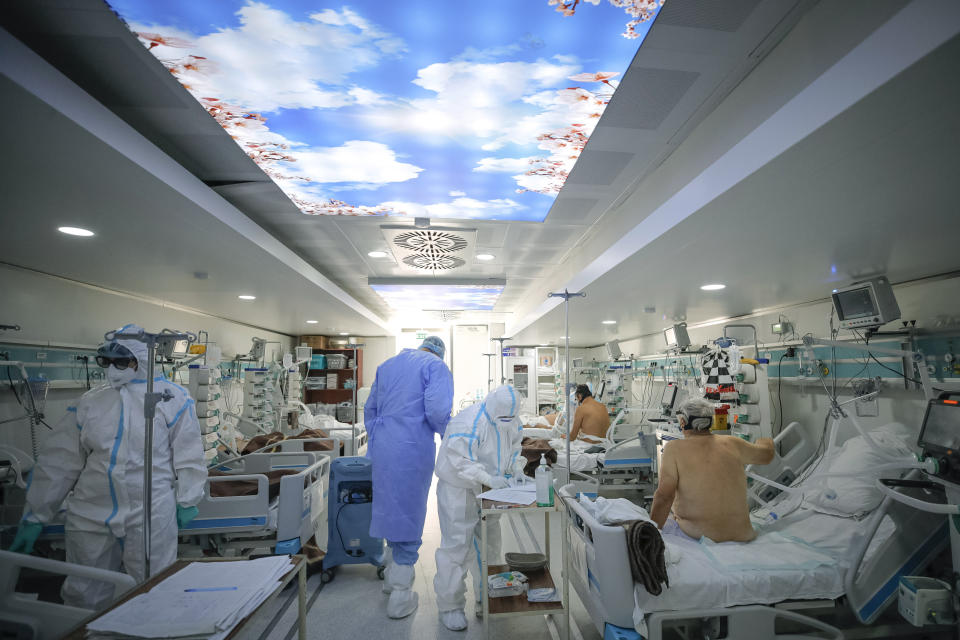 Medical staff attend to COVID-19 patients in a mobile ICU unit, set up on the hospital grounds to cope with the high numbers of seriously ill people at the Marius Nasta National Pneumology Institute in Bucharest, Romania, Wednesday, Oct. 6, 2021. (AP Photo/Andreea Alexandru)