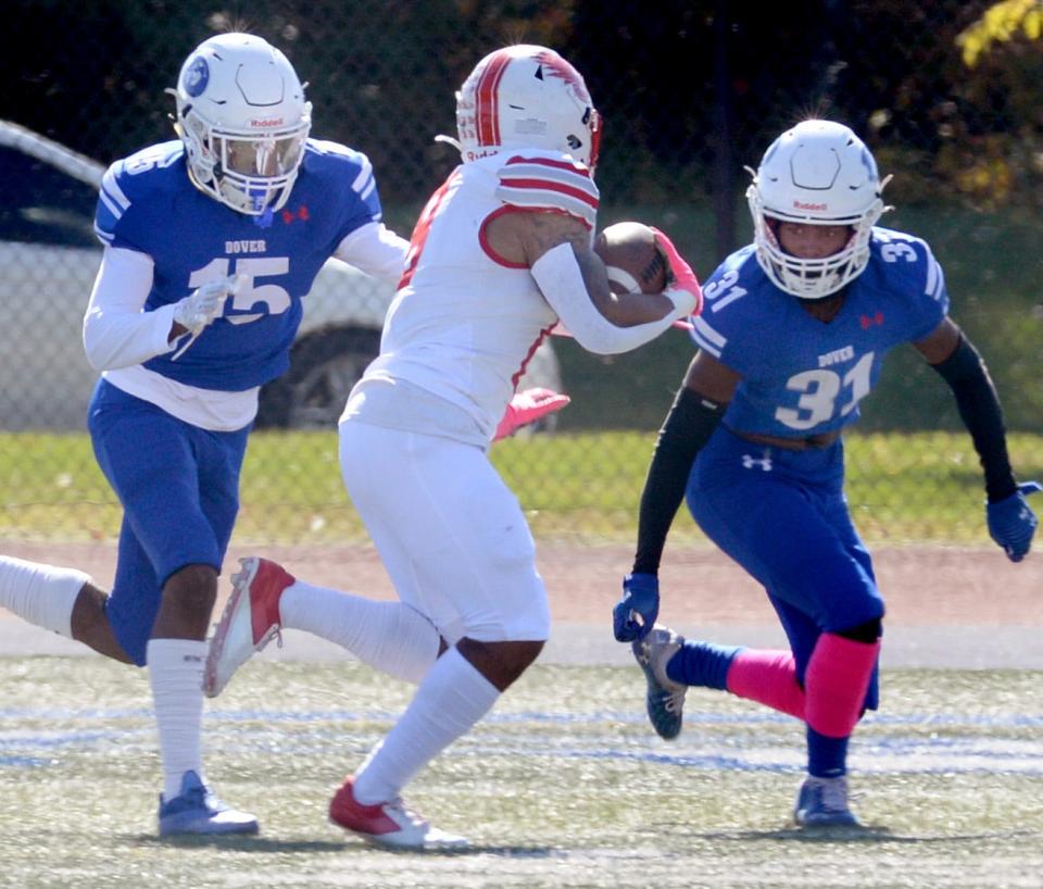 Dover defensive backs Ja'Khai Tilghman (15) and Tamir Darden Jefferson close in to stop Smyrna's Andre Ashley from a two-point conversion after the Eagles scored a touchdown in the first quarter.