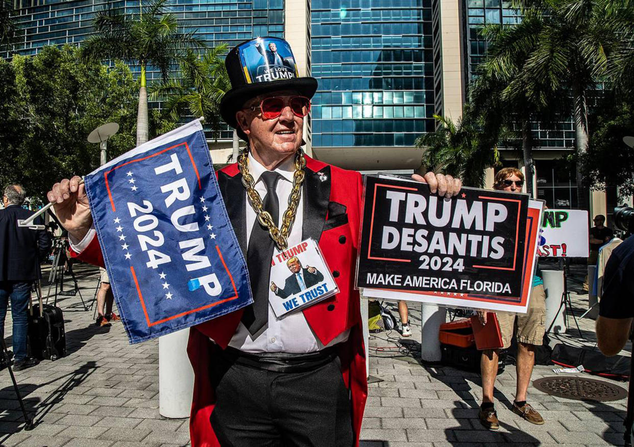Trump supporter Gregg Donovan, with Trump 2024 signs, stands in front of the Miami Federal Courthouse ahead of the former president's court appearance on Tuesday.