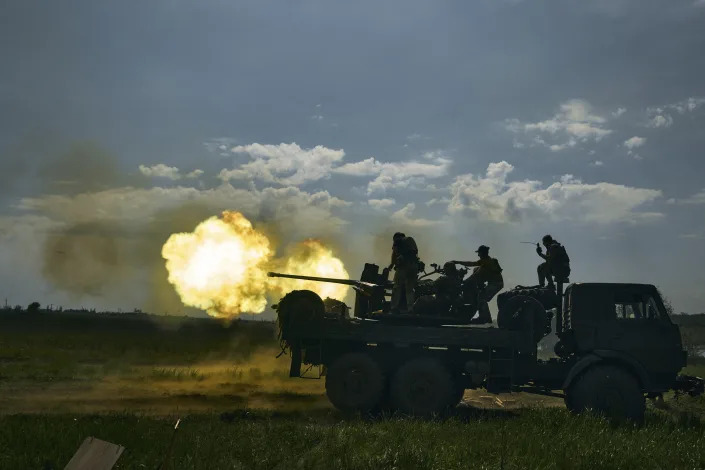 Ukrainian soldiers fire a cannon near Bakhmut, an eastern city where fierce battles against Russian forces have been taking place, in the Donetsk region, Ukraine, Monday, May 15, 2023. (AP Photo/Libkos)