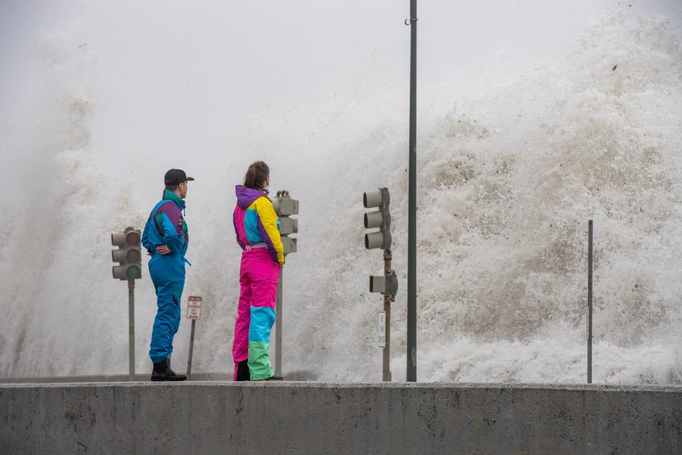 People watch waves crash over the sea wall in Revere, Massachusett (AFP via Getty Images)