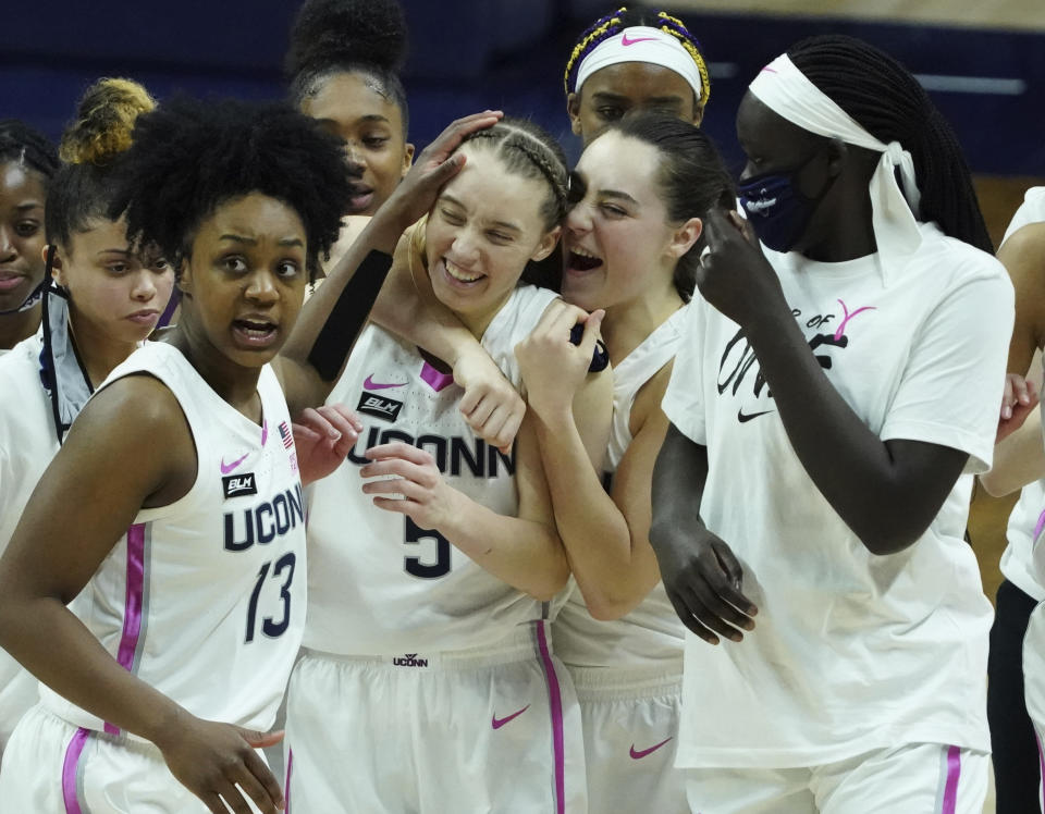 FILE - Connecticut guard Nika Muhl (10) hugs guard Paige Bueckers (5) after defeating South Carolina in overtime of an NCAA college basketball game in Storrs, Conn., in this Monday, Feb. 8, 2021, file photo. UConn has moved up to No. 1 in The Associated Press women's basketball poll, Monday, Feb. 15, 2021, for the first time this season after beating top-ranked South Carolina last week.(David Butler/Pool Photo via AP, File)