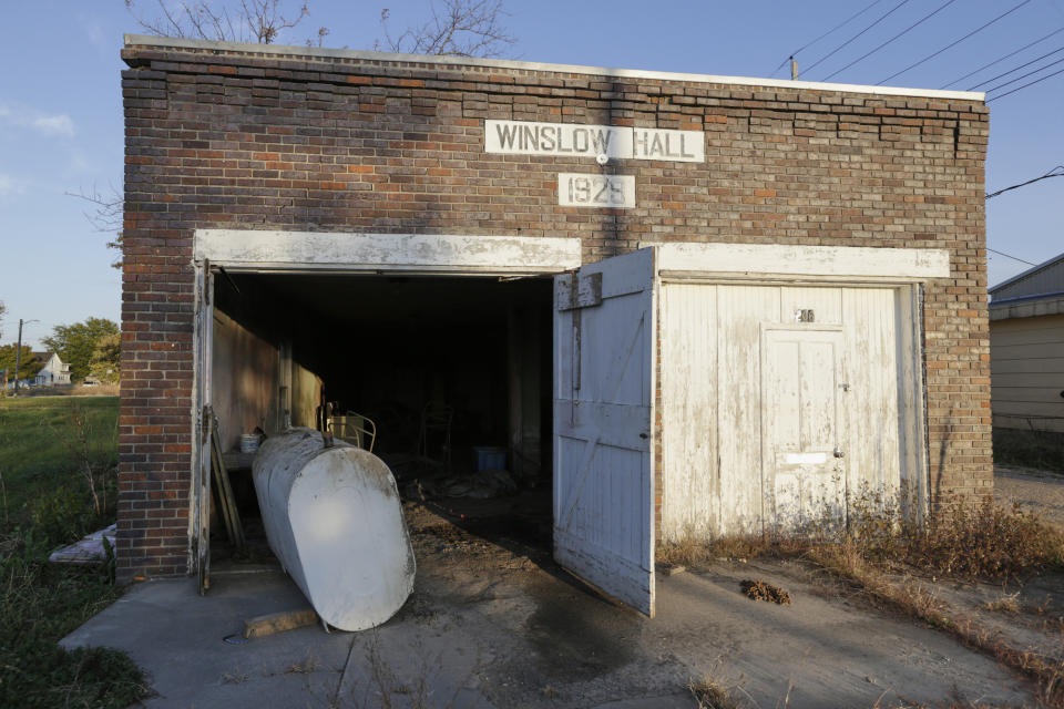 In this Oct. 24, 2019 photo, the doors to the Winslow Hall are left open following flooding from the Elkhorn River, in Winslow, Neb.. It took only minutes for swift-moving floods from the river to ravage tiny Winslow this spring, leaving nearly all its 48 homes and businesses uninhabitable. Now, the couple dozen residents still determined to call the place home are facing a new challenge: Moving the entire town several miles away to higher ground. (AP Photo/Nati Harnik)