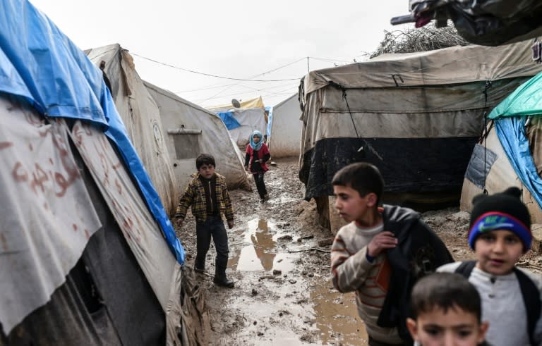 Refugee children walk between tents at a camp near the Turkish border in Bab al-Salama, near Azaz, northern Syria