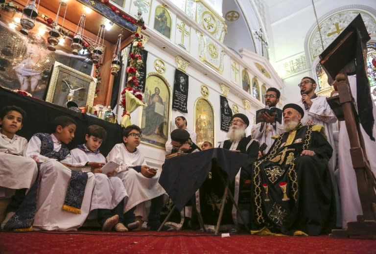 Egyptian boys and priests pray during the Good Friday procession at the St. George church in the town of Mahalla in northern Egypt on April 14, 2017