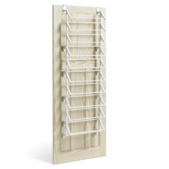 White over door shoe rack on a pale wood door on a white background