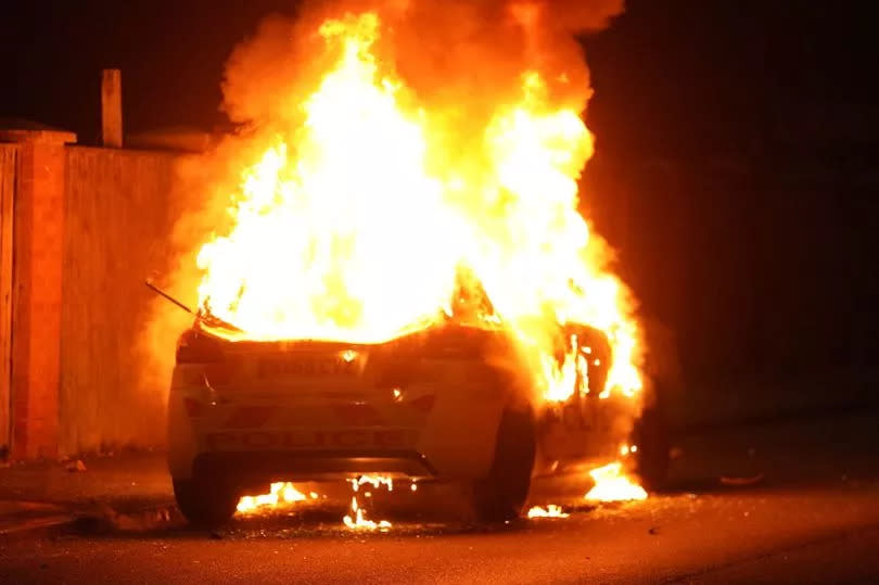 A police car burns as officers are deployed on the streets of Hartlepool following a violent protest. July 31