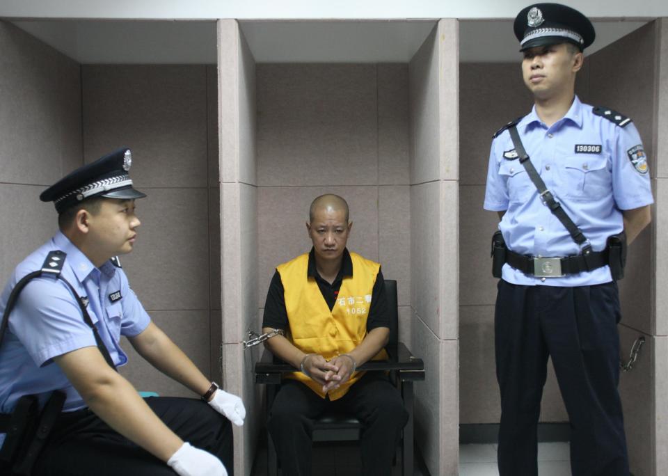 In this photo provided by China's Xinhua News Agency, defendant Lu Yueting, center, awaits his trial at the Shijiazhuang Intermediate People's Court in Shijiazhuang, capital of north China's Hebei Province, Tuesday, July 30, 2013. The former food plant worker in China on Tuesday confessed in court to poisoning frozen dumplings that sickened 10 people in Japan in 2008, a scandal that strained Beijing-Tokyo relations just months before China hosted the Olympic Games. (AP Photo/Xinhua, Ding Lixin) NO SALES