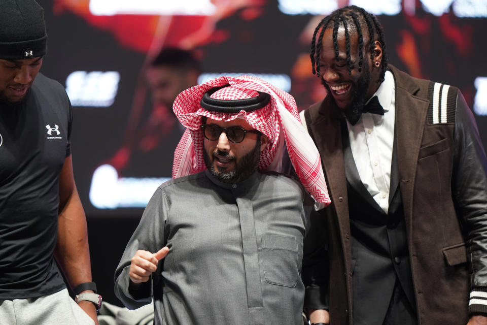Turki Al-Sheikh (C) of Saudi Arabia poses with Anthony Joshua (L) and Deontay Wilder (R). Wilder and Joshua will fight in separate bouts on a Dec. 23 card in Riyadh, Saudi Arabia.