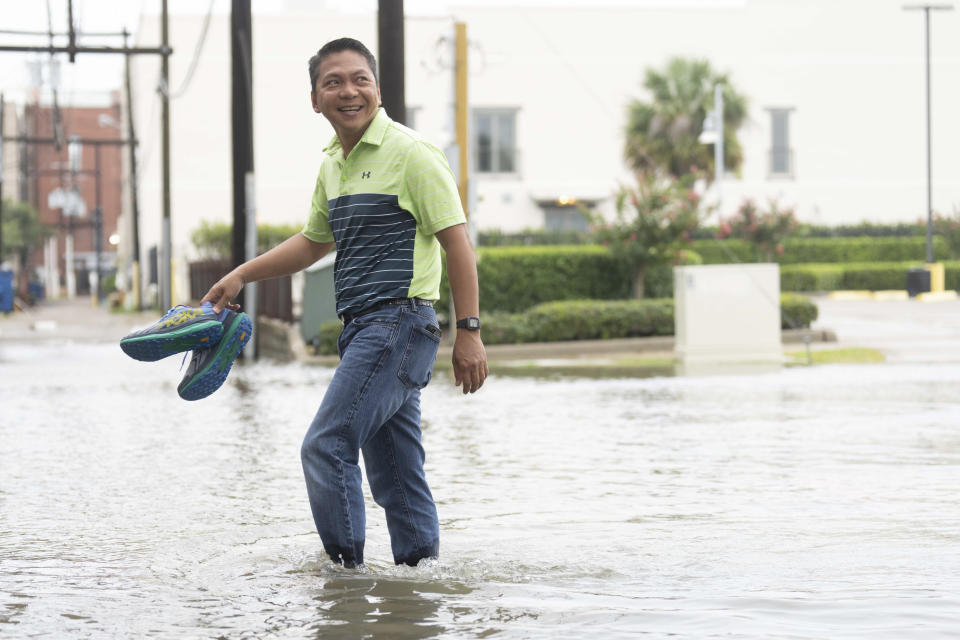 Roy Quiroz looks back at his wife, Minda, as he crossed a flooded section of Kempner Street, Wednesday, June 19, 2024, in Galveston, Texas. Tropical Storm Alberto has formed in the southwestern Gulf of Mexico, the first named storm of what is forecast to be a busy hurricane season. (Jason Fochtman/Houston Chronicle via AP)