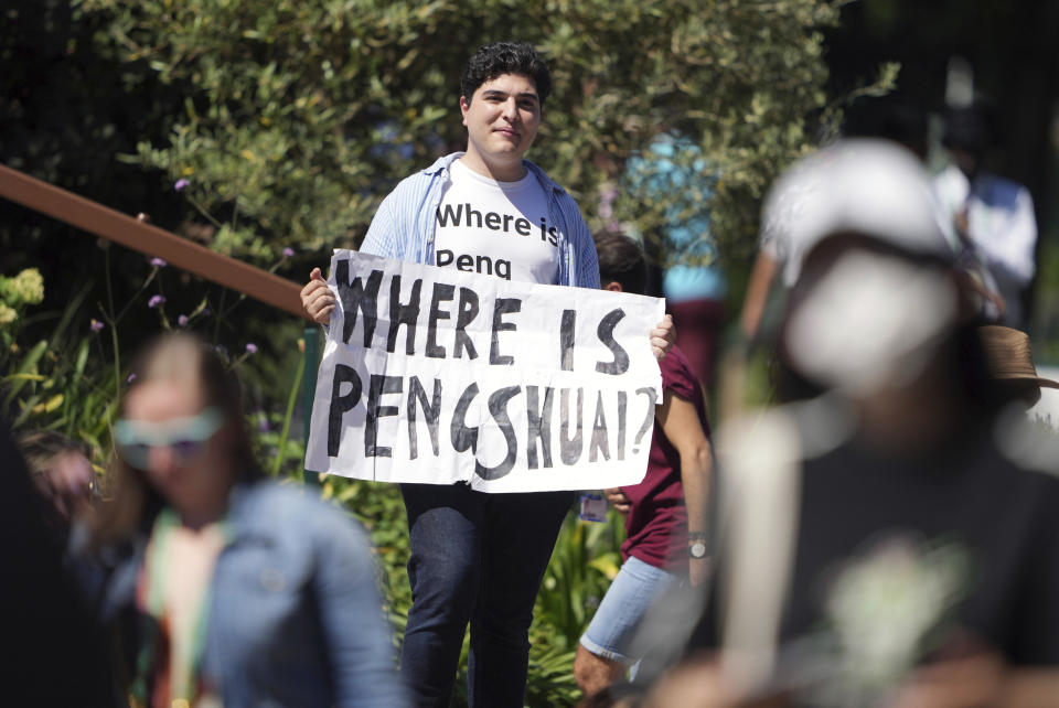 A protester holding a sign and wearing a t-shirt reading "where is Peng Shuai" on day twelve of the 2022 Wimbledon Championships at the All England Lawn Tennis and Croquet Club, Wimbledon, London, Friday July 8, 2022. Peng is a retired professional tennis player from China who last year accused a former high-ranking member of the country’s ruling Communist Party of sexual assault. She has made very few public appearances since then. (Zac Goodwin/PA via AP)