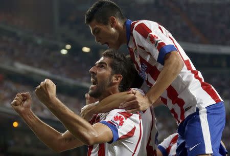 Atletico Madrid's Raul Garcia (L) celebrates with team mate Raul Jimenez after scoring a goal against Real Madrid during their Spanish Super Cup first leg soccer match at Santiago Bernabeu stadium in Madrid August 20, 2014. REUTERS/Sergio Perez