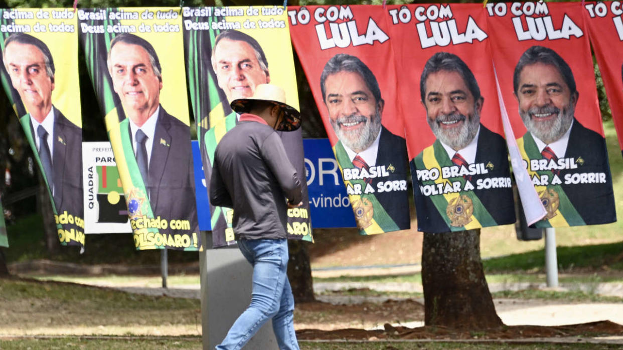 Towels with the images of presidential candidates Jair Bolsonaro and Luiz Inacio Lula da Silva are seen for sale at a street in Brasilia, on September 27, 2022. - Brazil entered the final stretch of the presidential campaign, a high voltage electoral duel between archrivals Jair Bolsonaro and Luiz Inácio Lula da Silva that, according to polls, could be defined already in the first round on October 2 in favor of the former president. (Photo by EVARISTO SA / AFP)