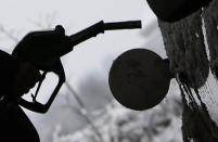 A woman fills petrol into her car at a filling station in Puchheim westward of Munich December 12, 2008. REUTERS/Michaela Rehle (GERMANY) - RTR22IF0