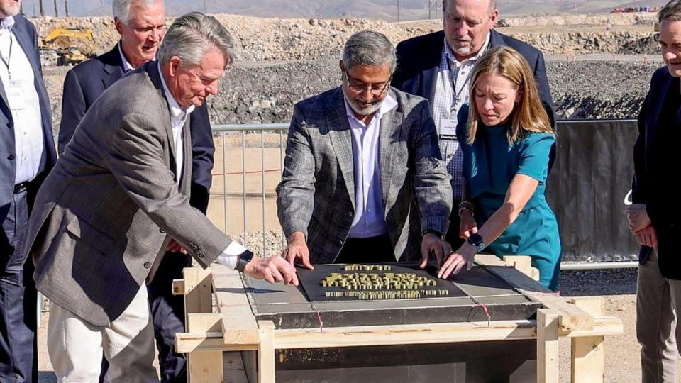 Micron CEO Sanjay Mehrotra, center, is joined Oct. 5 by Idaho Gov. Brad Little and Boise Mayor Lauren McLean to place a ceremonial plaque at the construction site of a new memory chip-making plant on Micron’s Southeast Boise campus.
