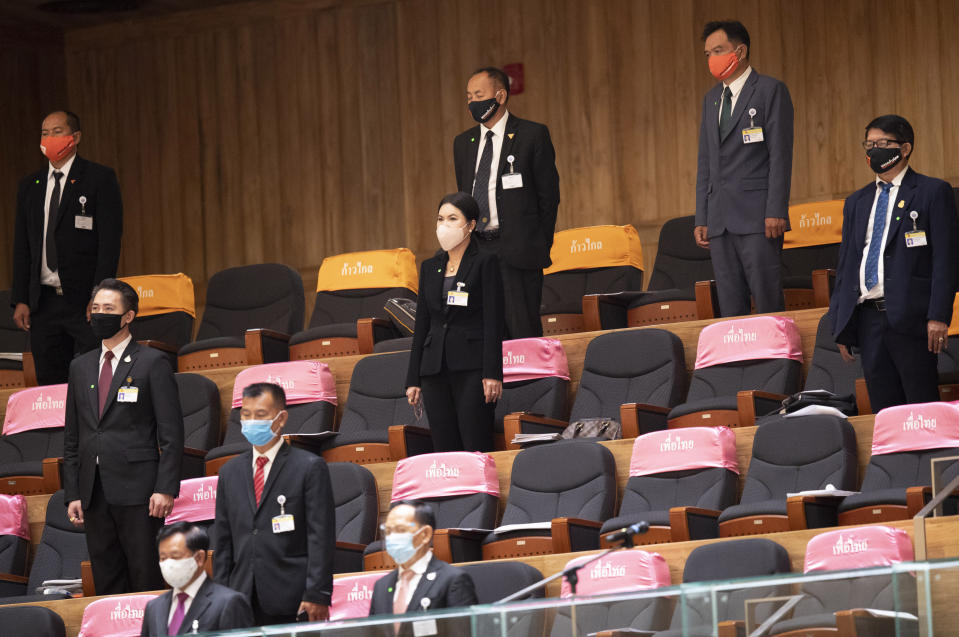 Members of parliament wearing face masks to help curb the spread of the coronavirus stand for an open session at the parliament house in Bangkok, Thailand, Wednesday, May 27, 2020. The parliament session Wednesday is the first since Thailand enforced coronavirus restrictions, and it was considered a special session to discuss the government’s plan to fund stimulus packages for businesses and industries impacted by the pandemic. (AP Photo/Sakchai Lalit)