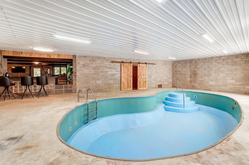 This Celina home for sale features an indoor pool, with a pub in the background.