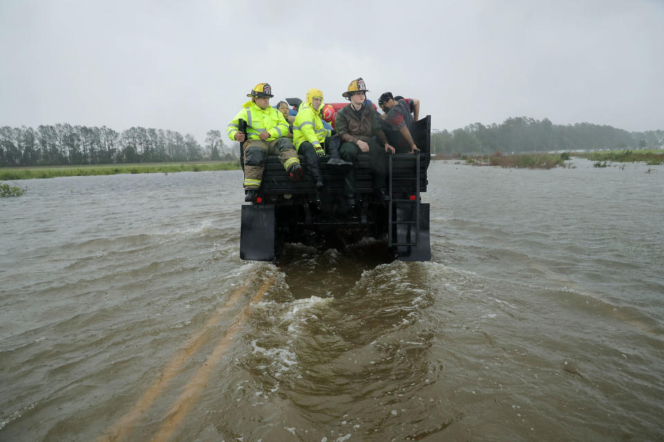 Rescue workers from Township No. 7 Fire Department and volunteers from the Civilian Crisis Response Team use a truck to move people rescued from their flooded homes during Hurricane Florence in James City on Friday.