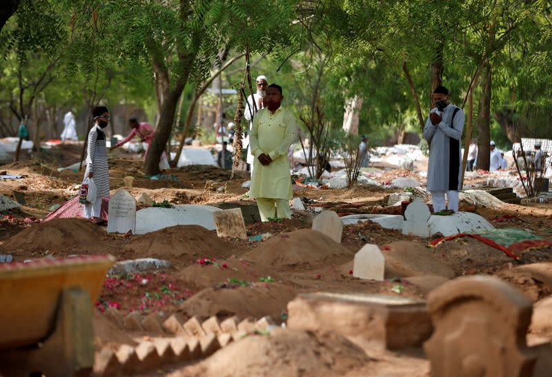 Muslims pray next to the graves of their relatives including those who died from the coronavirus disease (COVID-19), on the occasion of the Eid al-Fitr amidst the spread of the disease in Ahmedabad