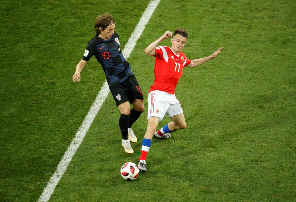 <p>Luka Modric in action with Russia’s Aleksandr Golovin </p>